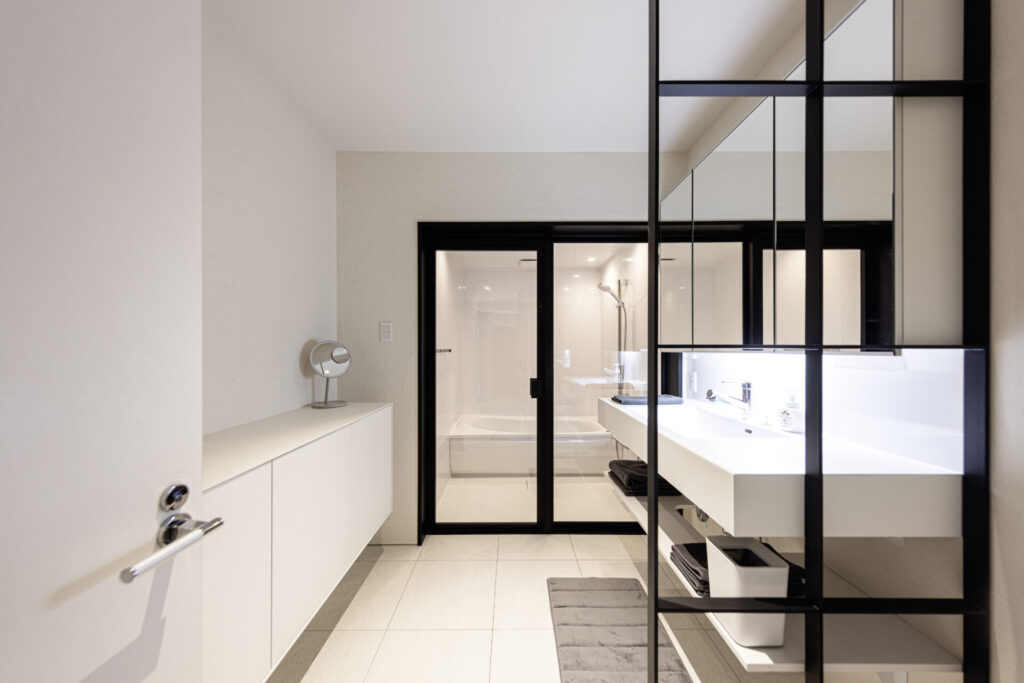 浴室・洗面・トイレをひとつのエリアにまとめ、身支度から入浴までをスムーズに行える動線に。洗面とトイレは別の場所にも設け、家族が同じ時間帯に使う場合にも配慮しました。アイアンの間仕切りやホワイトの収納を取り入れ、機能性だけでなくデザインにもこだわっています。